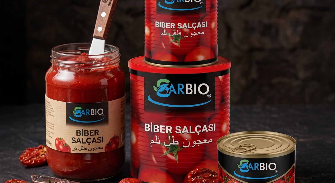 A gourmet food arrangement featuring assorted red peppers, a jar of traditional pepper paste, and tin cans
